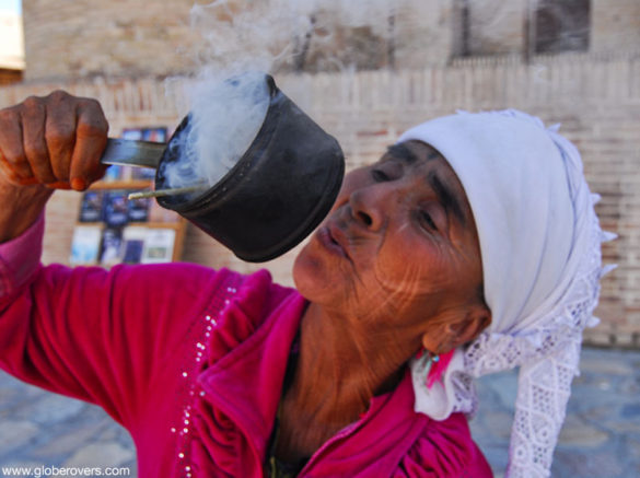 Smoke blowing woman near Kalon mosque and minaret, Bukhara, Uzbekistan