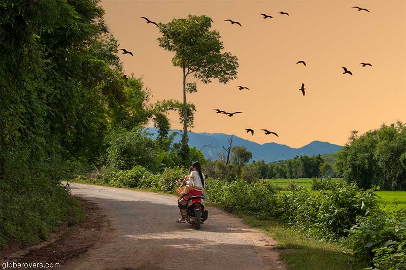 Girls on bike on the road east from Kengtung to villages, Shan State, Myanmar